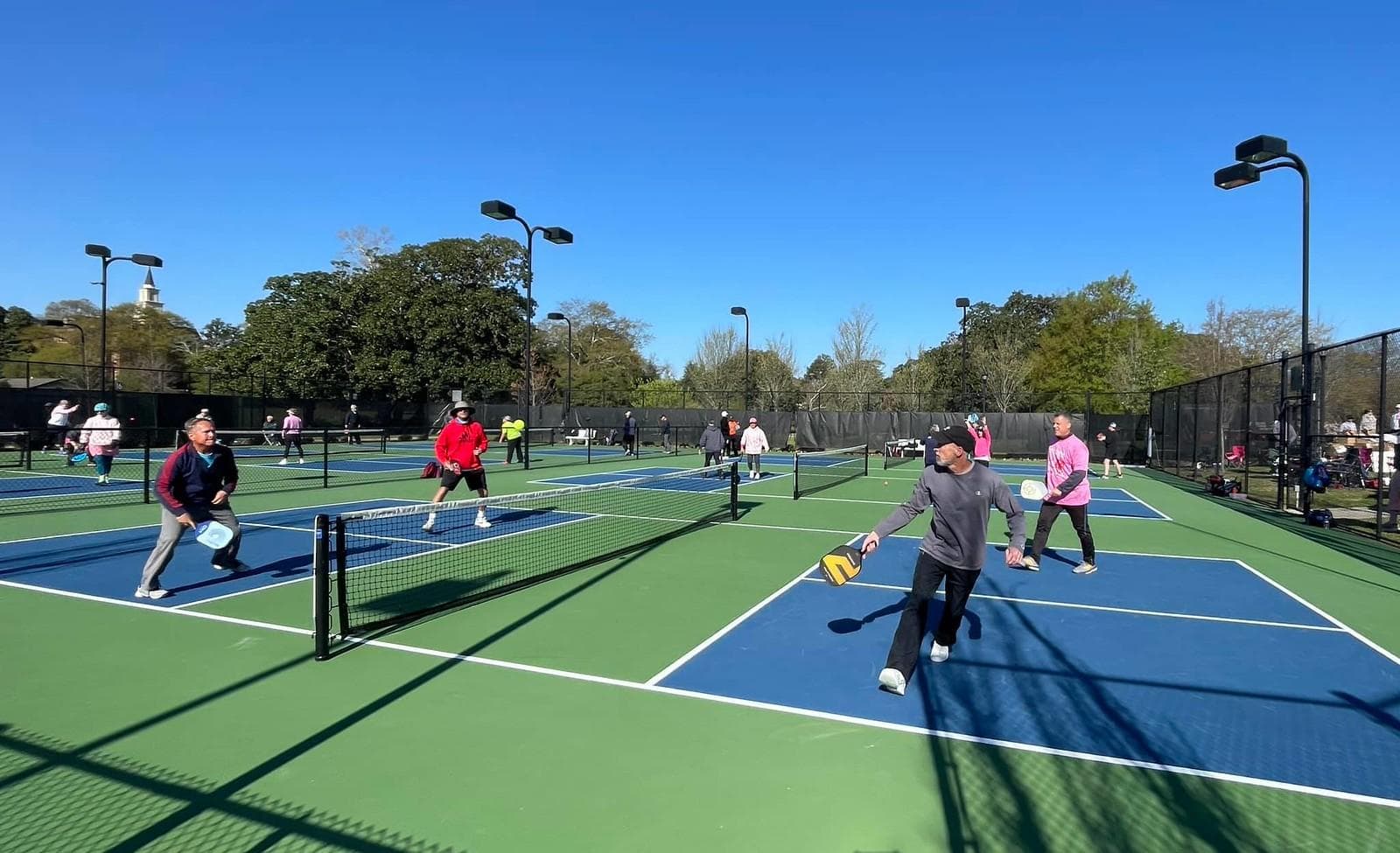 Texas pickleball players mid-rally on outdoor courts